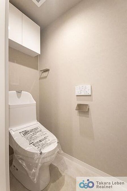 ウォシュレット機能付きのトイレは壁掛けリモコンの上位グレードを採用。便座がスッキリした印象となり、限られた空間を広く見せる効果があります。