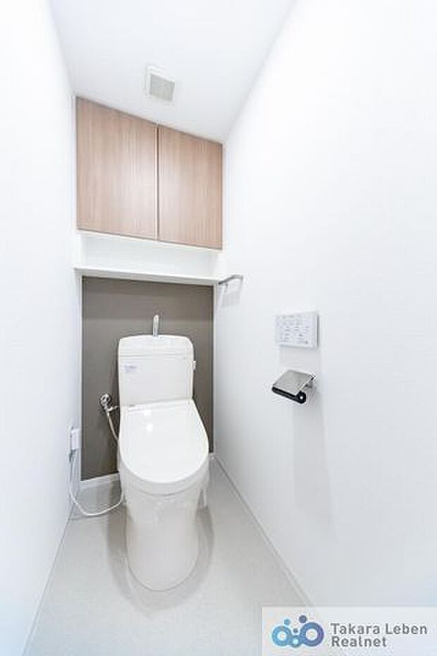 お洒落で清潔感のあるトイレ。トイレットペーパーホルダーとタオル掛けは標準で実装してます。上部に吊戸棚があり、掃除用具などの収納場所に困りません。