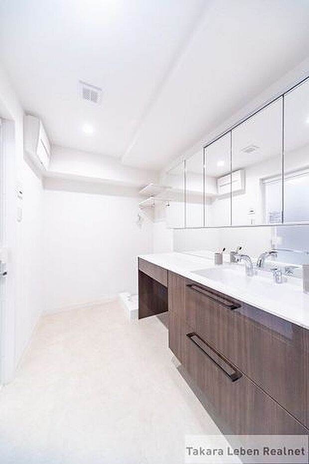ゆとりのある洗面室。便利な収納スペースがございますので、アメニティやタオル類の格納としてお使いになれます。