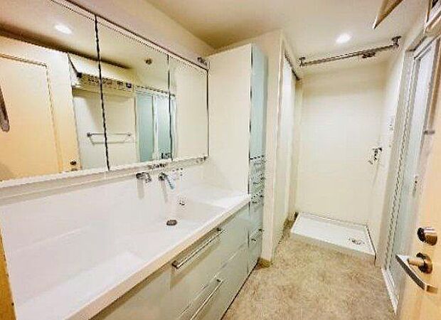 ワイドな三面鏡洗面台。鏡が大きく洗面室が広く感じられます。鏡裏にも収納可能の他、下収納やサイドに棚やリネン庫を設けた豊富な収納設備です。