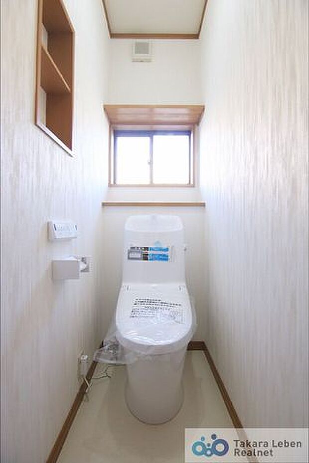 1階温水洗浄トイレ。背面に小窓があり、採光・換気良好です。