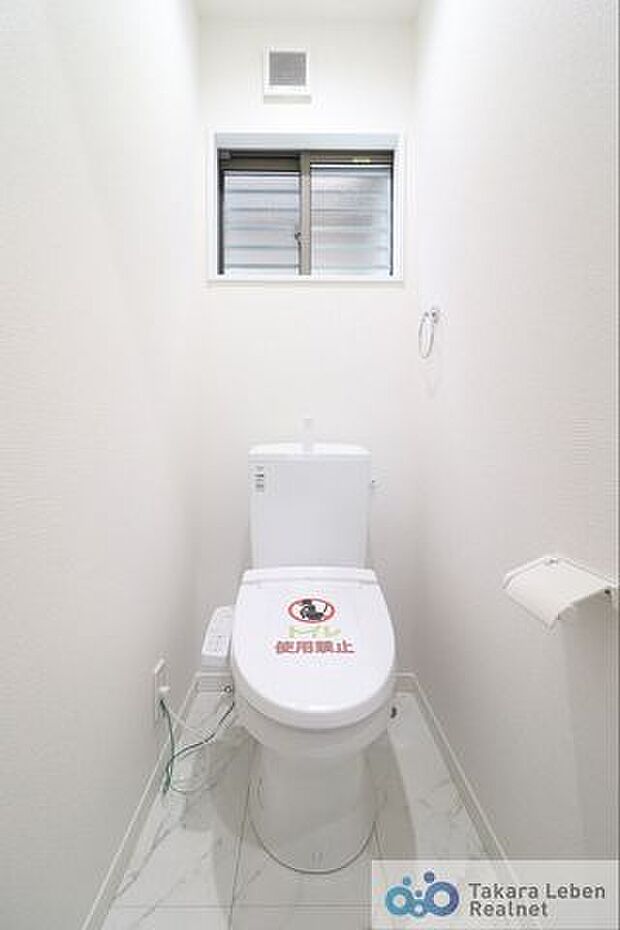 大理石調の床を使用した、2階の温水洗浄トイレ。トイレも小窓付き。