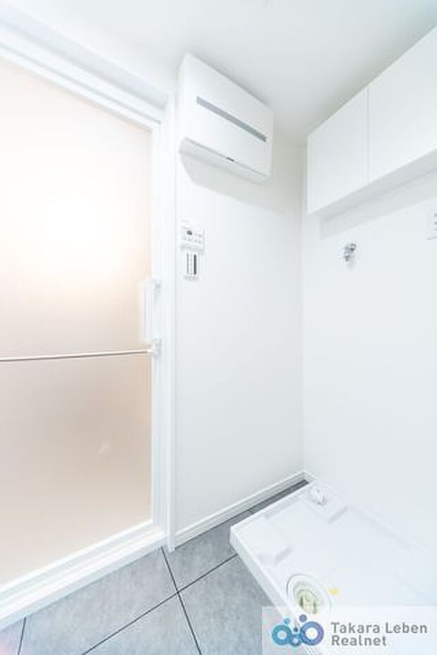 洗面スペースの化粧台背面には防水パン付きの洗濯機置場があります。また、上部には吊り戸棚が設置されている為、洗剤類の収納場所としてお使いになれます。