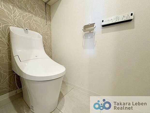 収納棚付き温水洗浄トイレ。リモコンは操作がしやすい壁掛けタイプです。