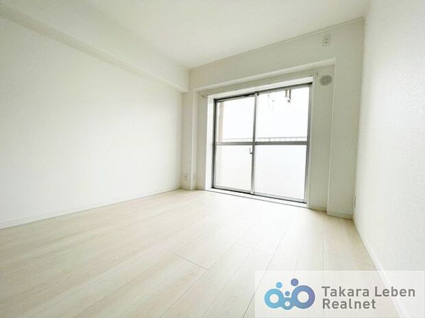 リビング隣洋室：大きな掃き出し窓からお部屋の隅々まで暖かな採光と通風が得られます。