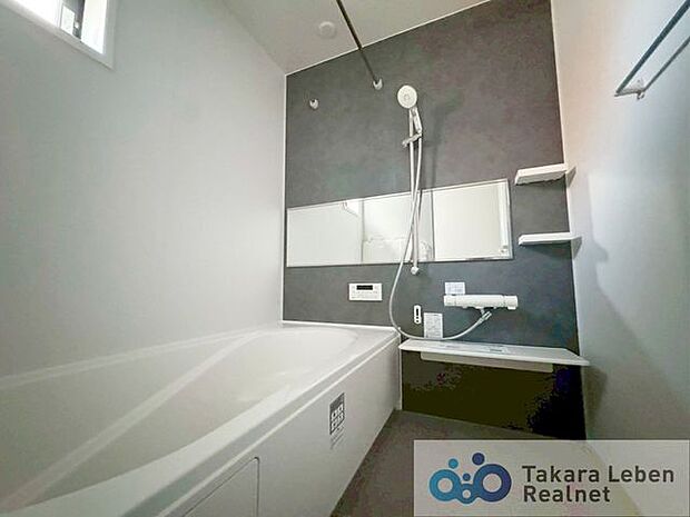 落ち着いた色のアクセントパネルを使用しシンプルかつ、清潔さを感じさせるバスルーム。