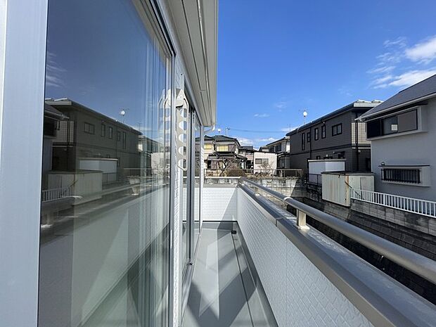 青空と建物が映り込む、開放感あふれるバルコニー空間