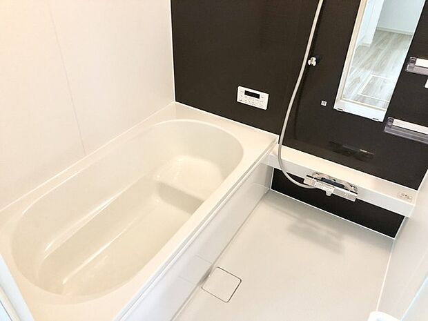 白と黒が調和する、洗練されたバスルーム空間。