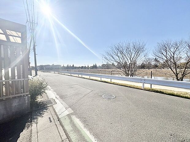 広がる空の下、穏やかな水辺の風景が広がる小道