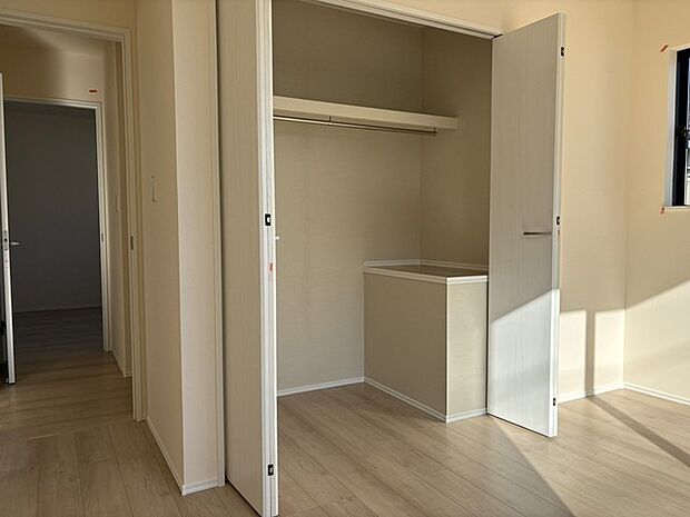 大きな壁面収納。広々とした空間に、柔らかな木目調の床が温かい印象を与えます。