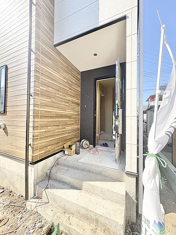 自然な木目調の外壁と、開放的な玄関が温かく迎えてくれる住まい。