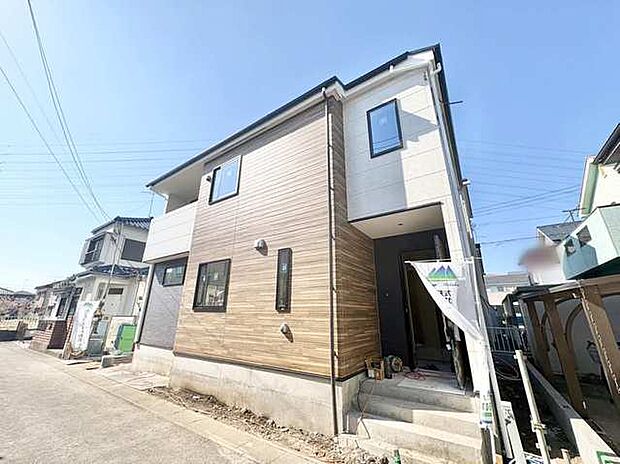 温かみのある木目調の外壁が、晴れた空に映える佇まい。