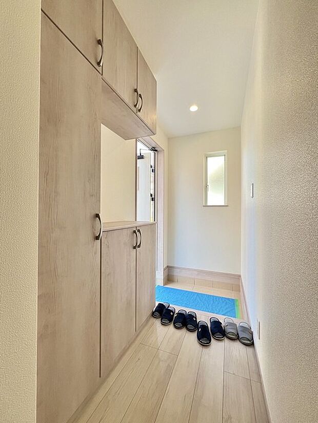 淡い木目調の玄関が、空間に温かみと広がりをもたらす