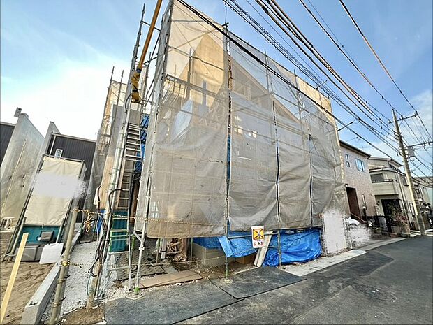 空と建物を覆うシートが、静かな工事の情景を醸し出しています。
