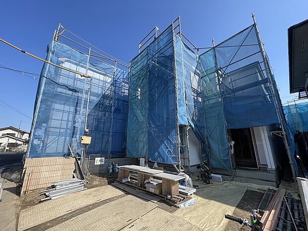 建築中の確かな未来を、青いシートが包み込む。