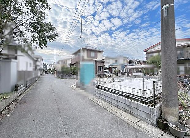 青空と雲が広がる、穏やかな住宅街の風景。