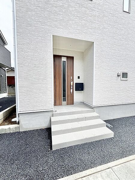 洗練された質感の白い外壁と木のぬくもりが調和し、住まう方を優しく迎え入れる落ち着いた佇まいです。