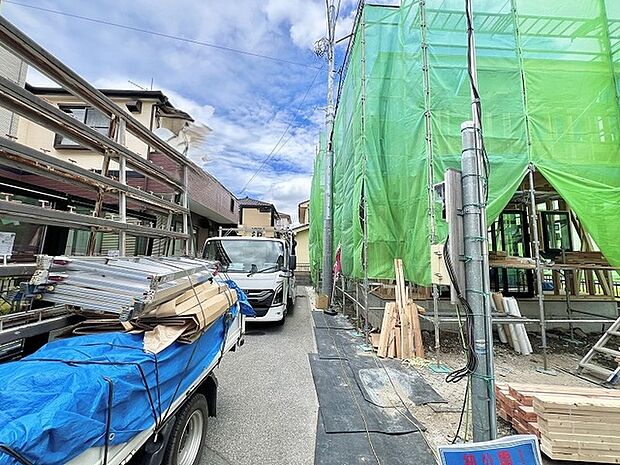 完成に向けた期待感が高まる、静かな住宅街に佇む建設現場の風景です。
