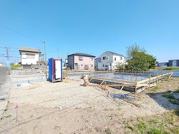 澄み渡る青空の下、新しい暮らしの基盤が整い、穏やかな街並みに溶け込む住環境が広がっています。