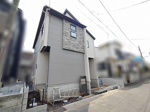 落ち着いた色合いの外壁に石張りのアクセントが映える洗練された佇まい