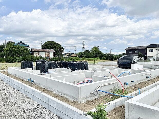 これからの暮らしの基盤となる、広々とした空の下で着実に進む建築現場の風景です。