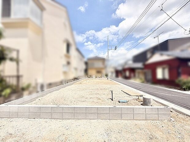 空が広く感じられる開放的な敷地で、周辺は落ち着いた住宅街の風景が広がっています。
