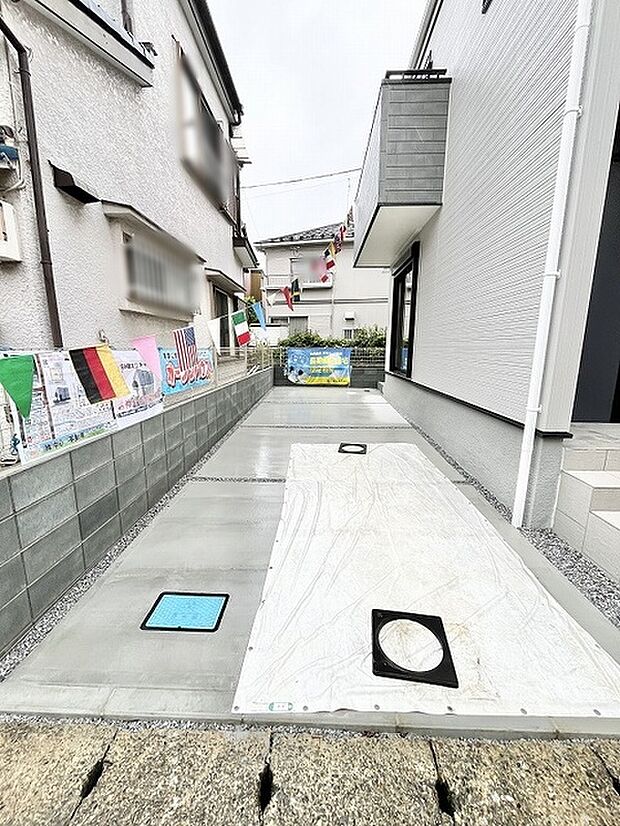 建物に挟まれたすっきりと舗装された敷地がゆとりある空間を生み出します