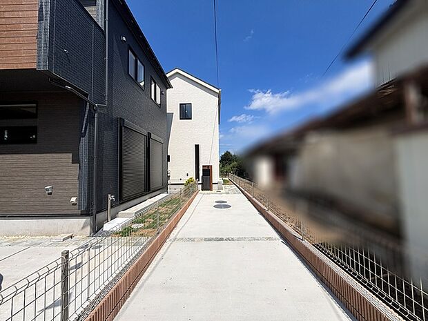 澄んだ青空の下、現代的な佇まいが並ぶ街並みに穏やかな日常の気配が漂います。