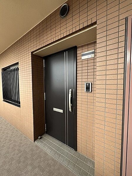 落ち着いた色合いのタイル壁が重厚感を醸し出す、洗練された佇まいの玄関まわり。