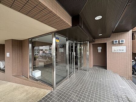 落ち着いた色合いのタイルとガラス張りが調和する、洗練された佇まいのエントランスです。