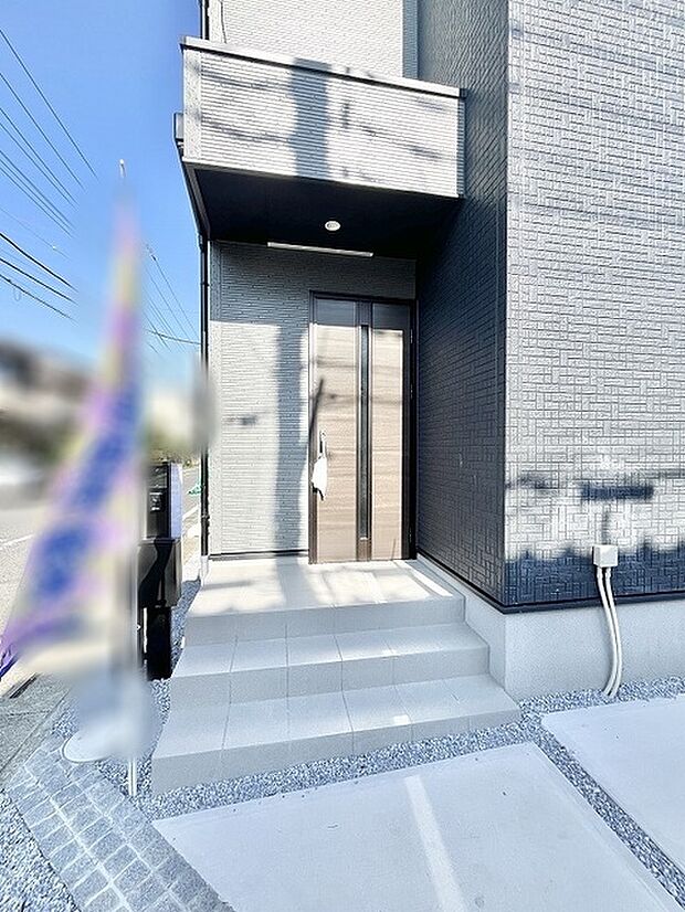 洗練された質感の外壁が印象的な、モダンで落ち着きのある佇まいのエントランスです。