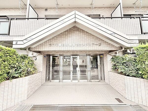 緑豊かな植栽とタイル貼りの外観が調和した、落ち着きと安心感のあるエントランスアプローチ