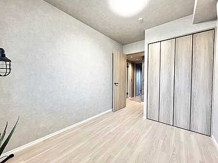 ニュアンスのあるグレーの壁面と優しい木目が調和する、落ち着いた佇まいの一室。