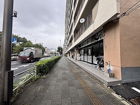 整然とした街路樹と歩道に面した、日常の利便性が感じられる心地よいアプローチ。