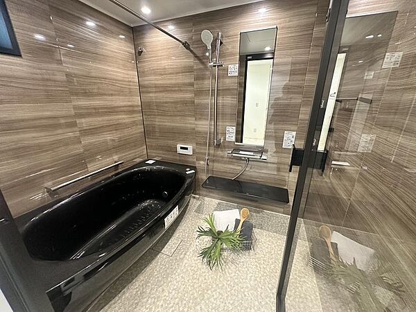 落ち着いた木目調で統一されたバスルーム。浴室暖房乾燥機を加え、天候を気にせず洗濯物を乾かせます。
