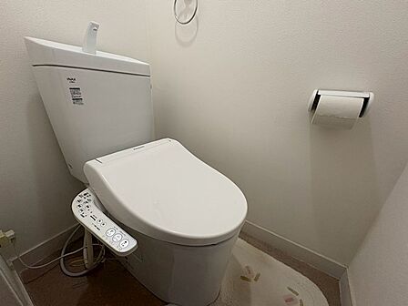 ウォシュレット設備で快適な温水洗浄便座付きの明るいトイレです。
