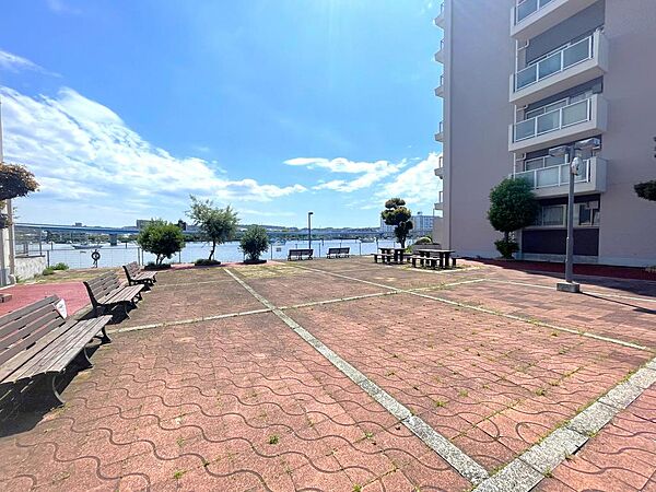 ベンチが配置され、ゆったりと過ごせる広場。水辺の景色を楽しめ開放的な空間が広がります。