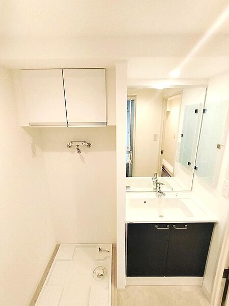 洗面化粧台のお隣が洗濯機置き場で、上部には棚も設けてありま。