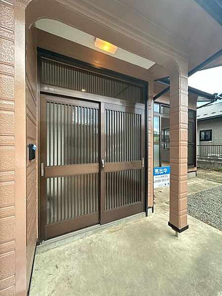 【リフォーム済】玄関ドアは交換を行いました。ポーチ部分の照明を新品交換しますので、お客様を迎える玄関廻りは、明るくスッキリとした印象に仕上がります。