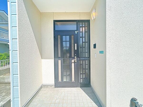 【リフォーム済】玄関ドアは鍵交換を行いました。ポーチ部分の照明を新品交換したので、お客様を迎える玄関廻りは明るくスッキリとした印象に仕上がりました。