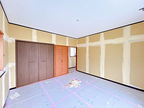 【リフォーム中】2階8帖洋室です。クロスの張替えとフローリング重ね張り、照明交換を行います。2面採光で、ベランダに出られるのが良いですね。
