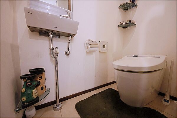 温水洗浄便座付きのトイレです。寒い時期でも温かな便座で快適に使うことができます。鏡付きの手洗い器が設置されており、いつでも清潔に利用できます。