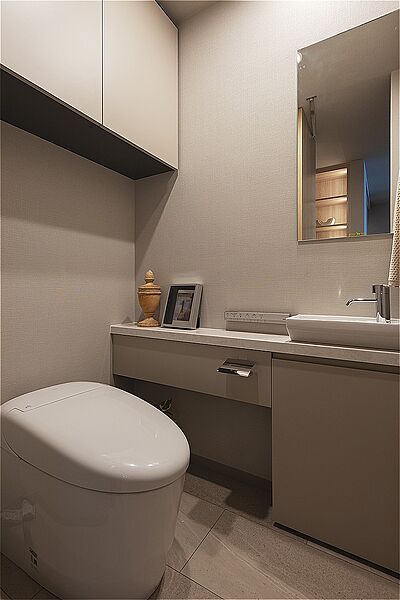 清潔感のあるトイレです。トイレットペーパーのストック置きに便利な収納付き。トイレ内に手洗い器を設置しているので、使用後すぐに手が洗えて衛生的です。