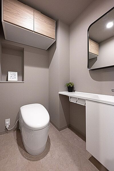 【トイレ】年中快適に利用できる、温水洗浄便座付きのトイレです。吊戸棚が備わっており、掃除道具・トイレットペーパーなどの収納に役立ちます。