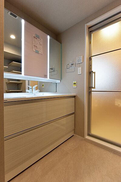 【洗面室】洗面化粧台は三面鏡＋ミドルミラー付きです。鏡裏とボウル下には収納スペースがあり、化粧品やヘアドライヤーを収納することができます。