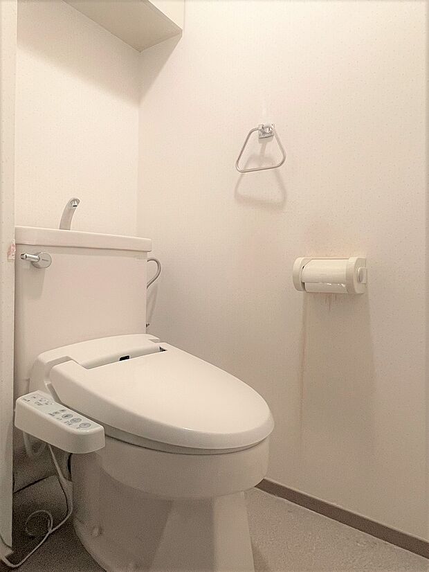 ホワイトを基調とした、清潔感溢れる温水洗浄便座付きのトイレです。