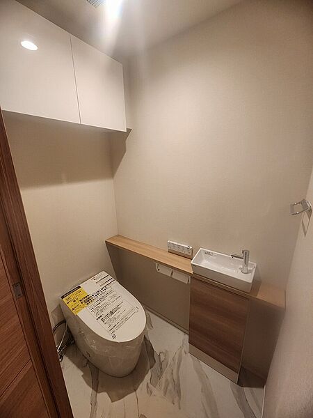 【トイレ】年間を通して快適に使用できる温水洗浄便座付き。独立式の手洗いスペースや収納棚など、使い勝手の良い設備が採用されています。