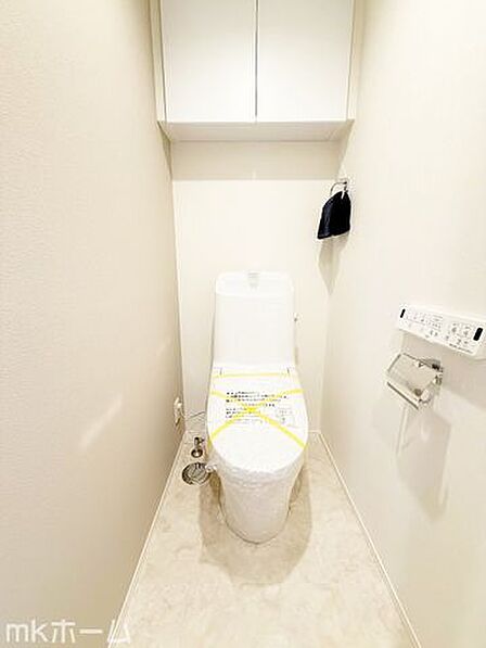 温水洗浄便座と吊戸棚を備え、ストック品もすっきり収まります。