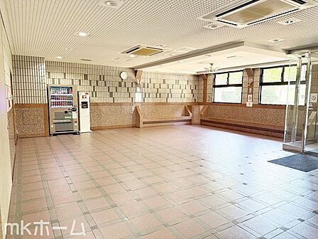 共用部 自動販売機とベンチを備えた広々としたエントランスロビー