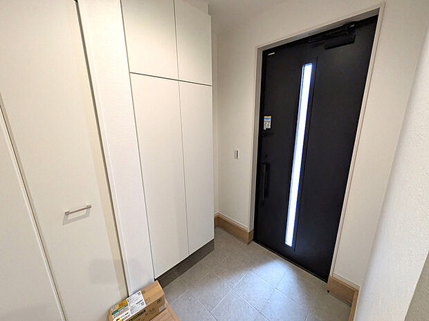 天井まで伸びる収納を設置した玄関